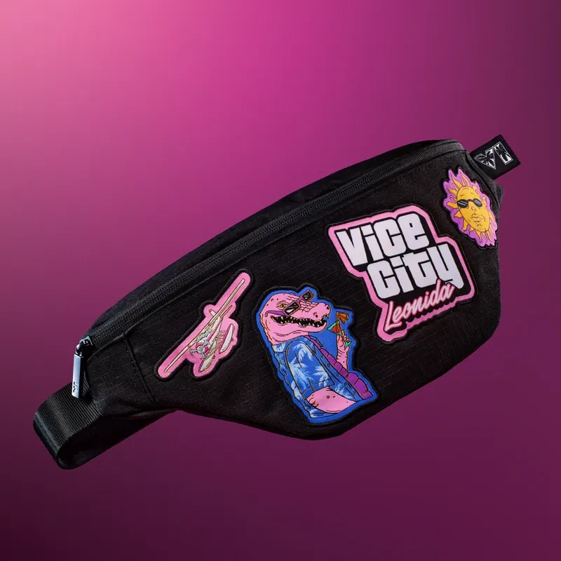 Riñonera negra con cuatro parches de colores: un hidroavión rosa, el caimán Macca, el rótulo «Vice City Leonida» y un sol con gafas.