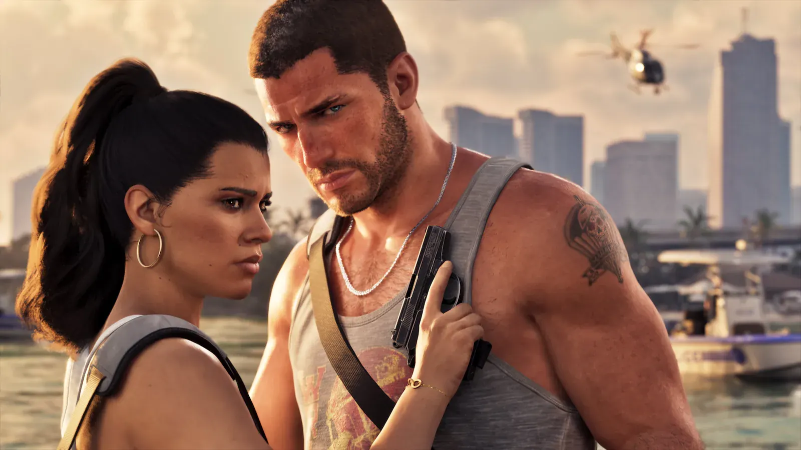 Primer plano de Lucia y Jason muy juntos y serios. Ella sostiene una pistola contra el pecho de él. Al fondo, rascacielos y un helicóptero policial.