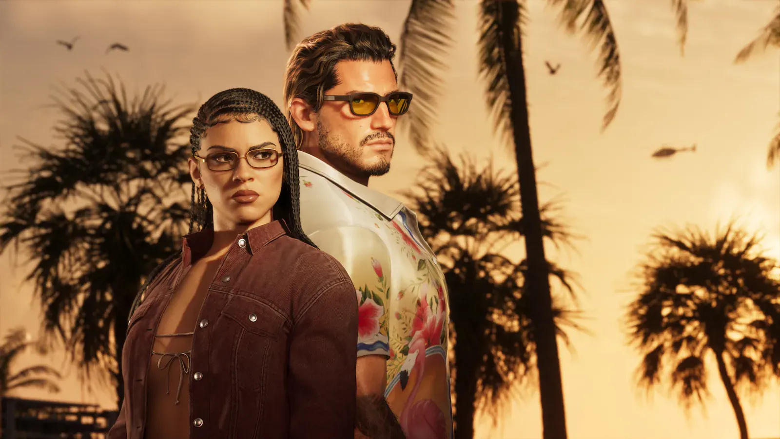 Lucia y Jason espalda contra espalda al atardecer, entre palmeras. Ella lleva trenzas, gafas y una chaqueta vaquera granate; él, gafas de sol ámbar y una camisa floreada con flamencos.